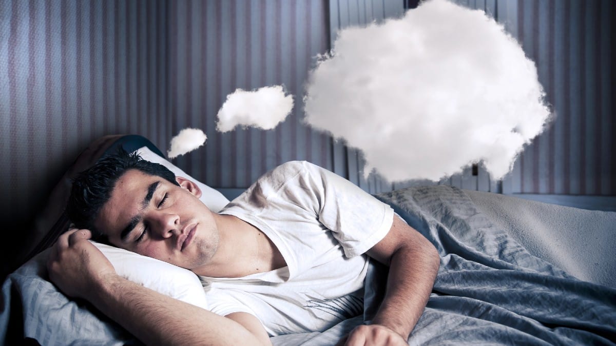 Man comfortably dreaming in his bed with a cloud 