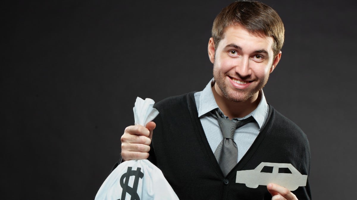 Man holding money bag and paper car