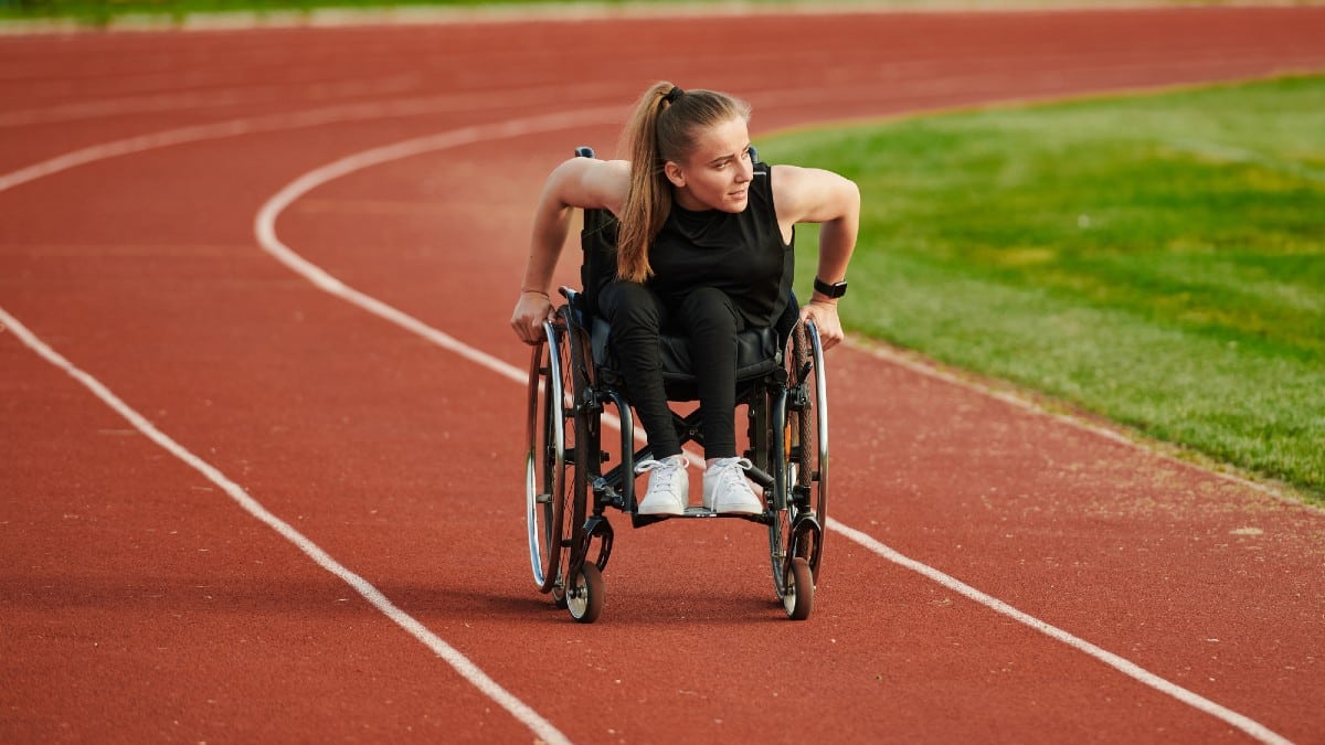 A woman with disablity driving a wheelchair on a track while