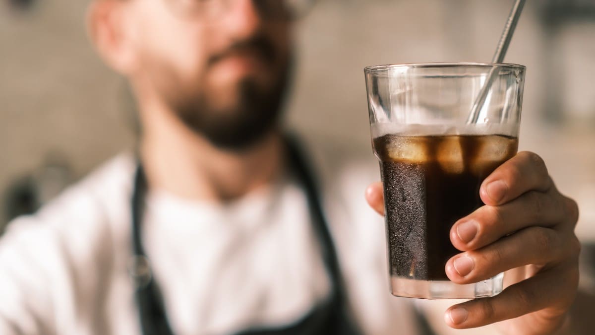 New Remove BG Save Share Sample New Barista holds a glass of cold brew coffee with ice