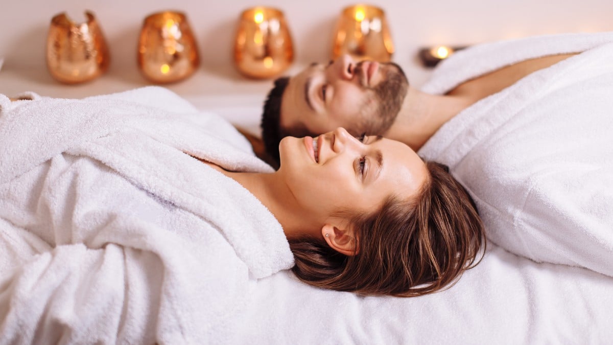 Man and woman lying down on massage beds at luxury spa and wellness center