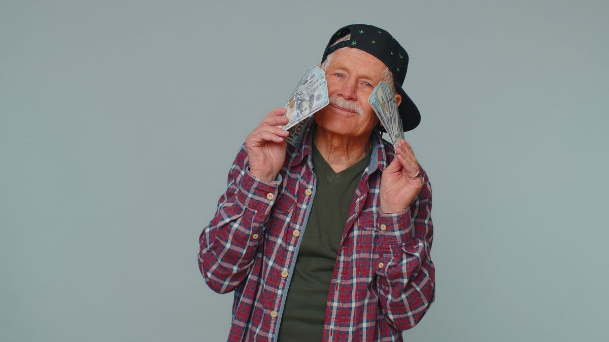 Rich pleased boss senior man waving money dollar cash banknotes