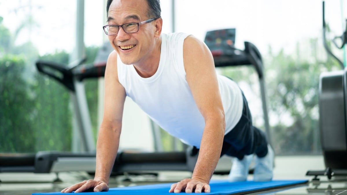 Senior man push up in fitness gym. Mature healthy lifestyle.