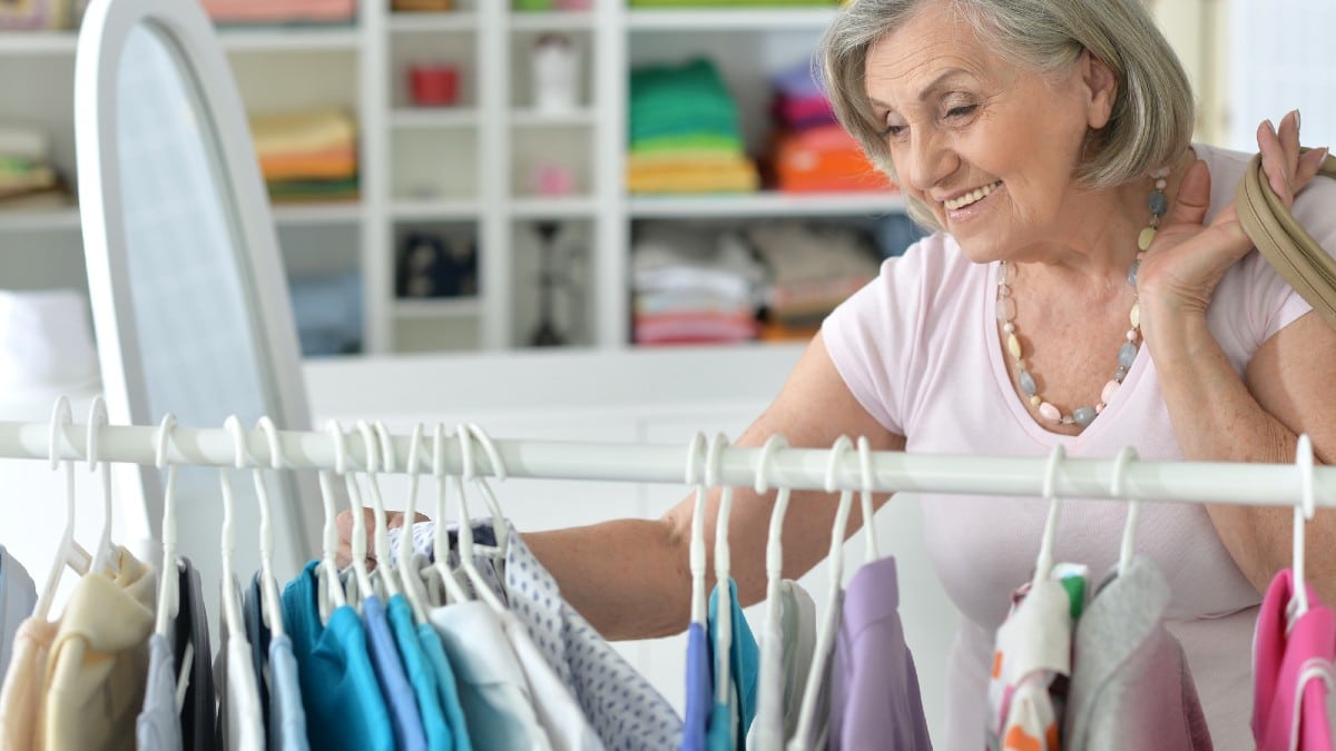 Senior woman choosing shirt in shop