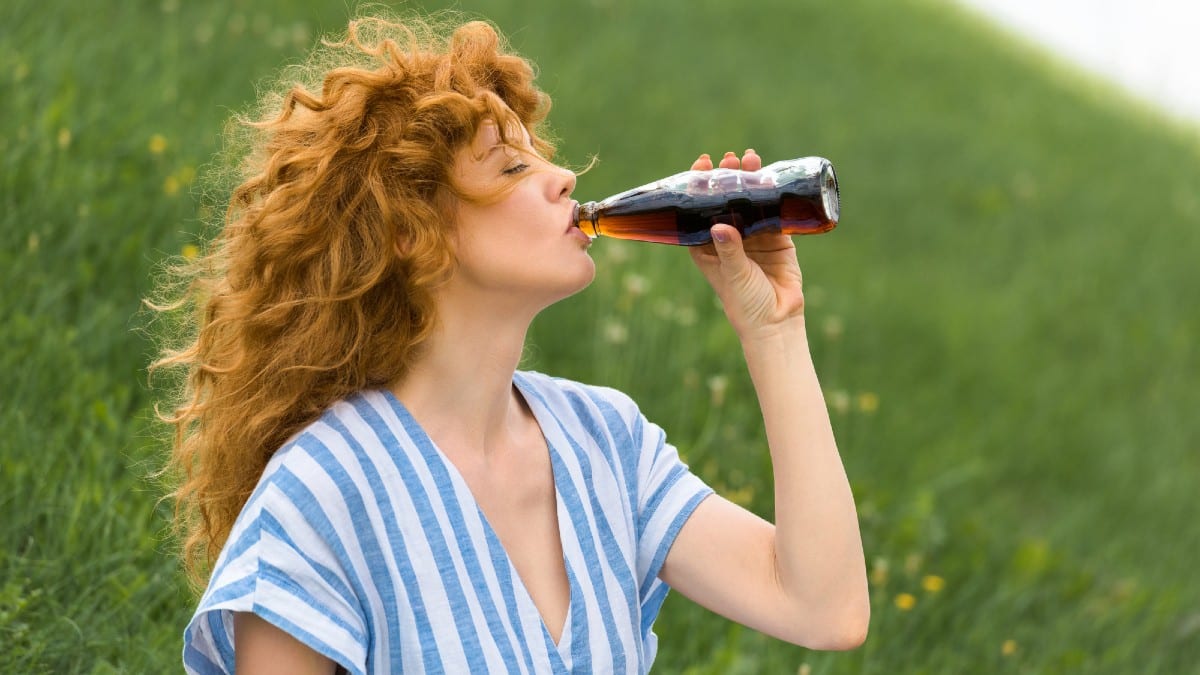 New Remove BG Save Share Sample New Side view of beautiful redhead woman drinking soda outdoors