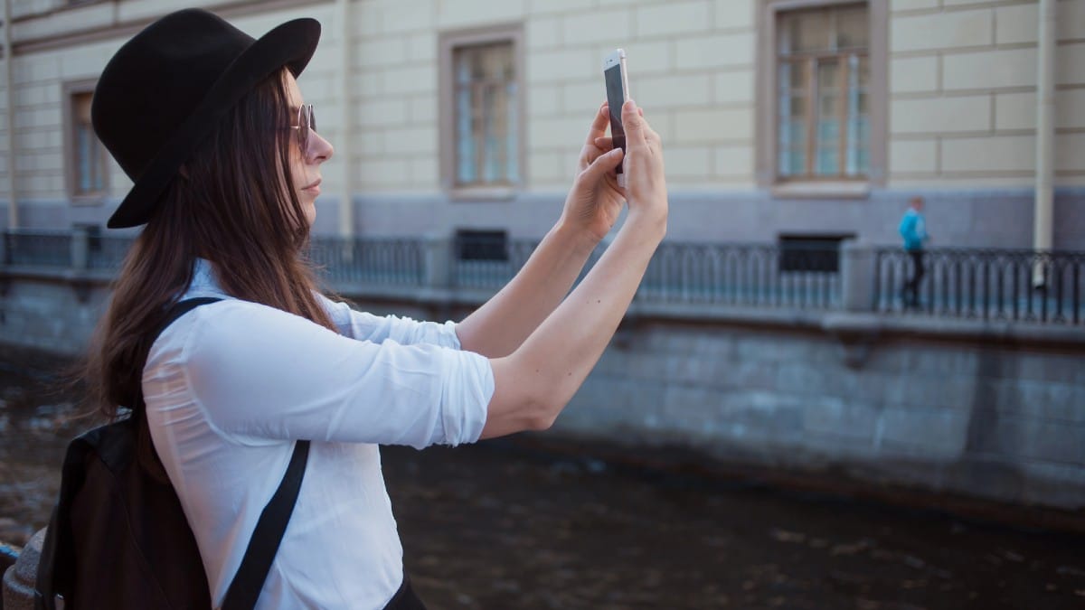 Tourist in the city takes a photo on smartphone.