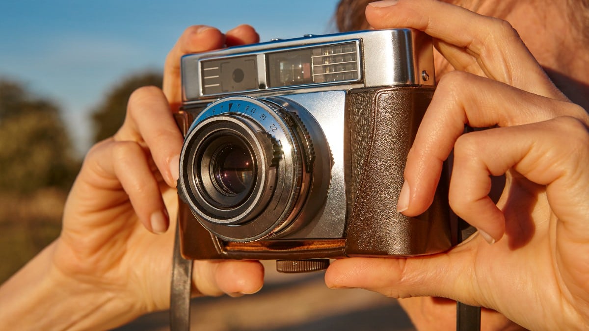 Woman taking pictures with vintage camera.