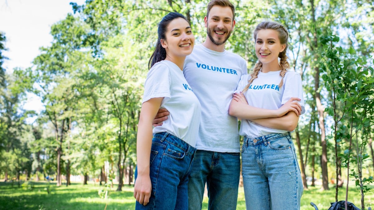 Young volunteers hugging in park together