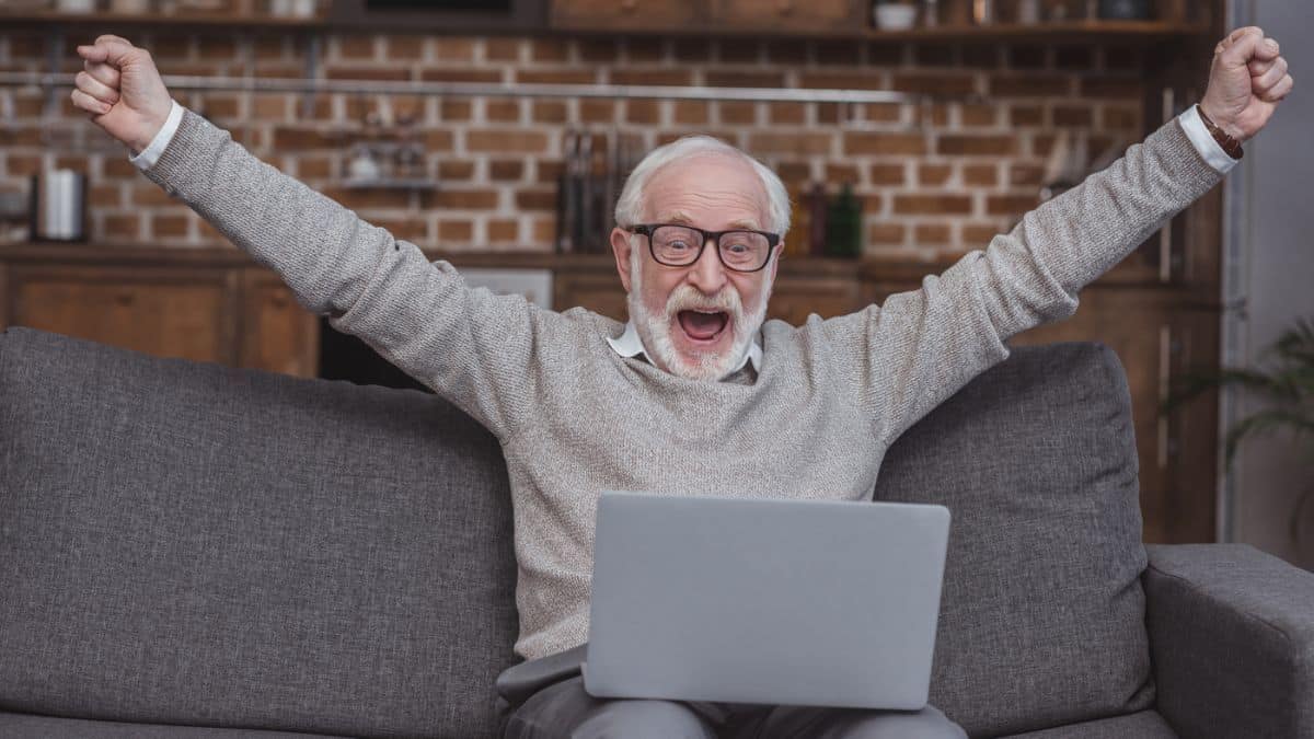 elder celebrating on a laptop