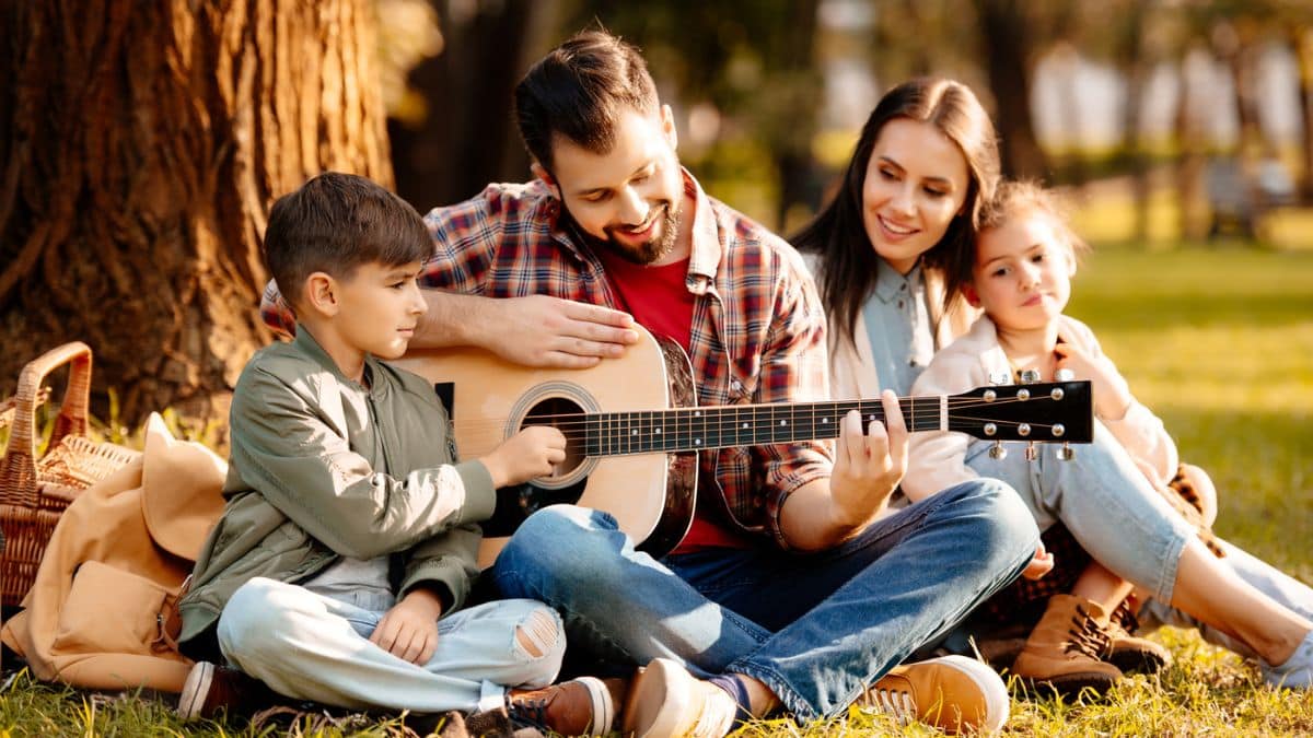 family playing guitar outside