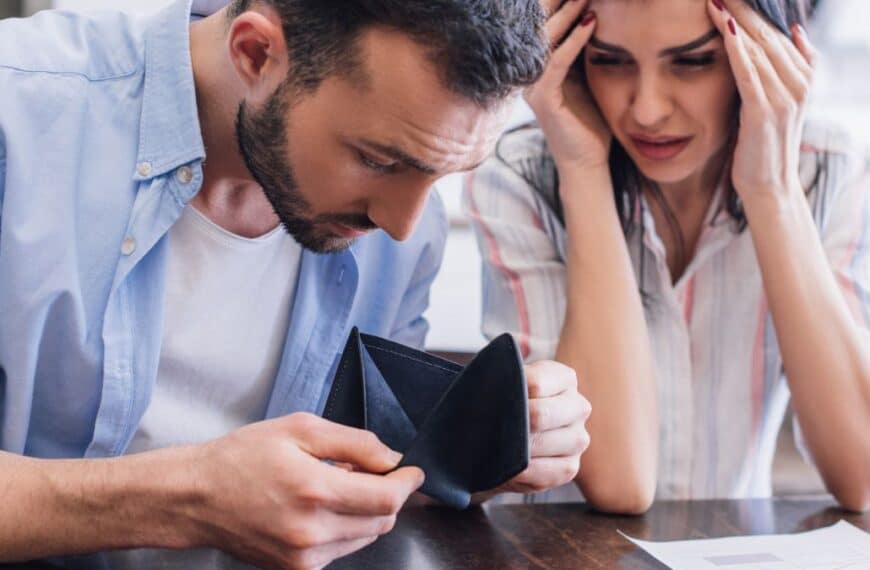 man and woman looking at empty wallet