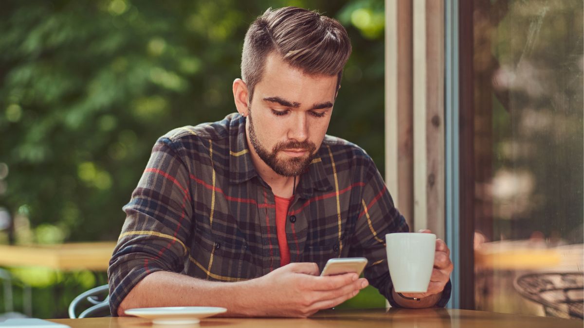 man drinking coffee and on phone