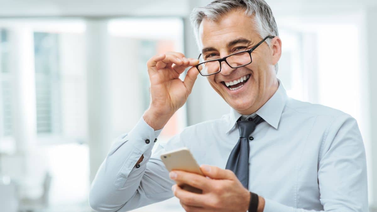 man with glasses on phone laughing