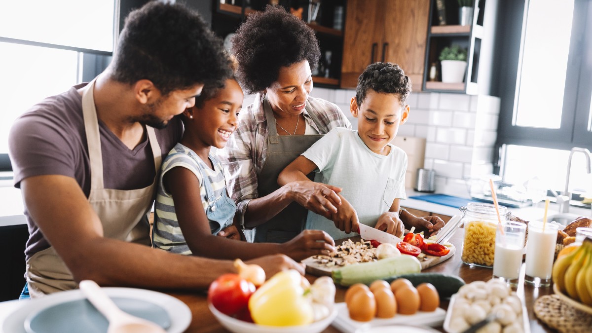 Happy african american family preparing healthy organic food together