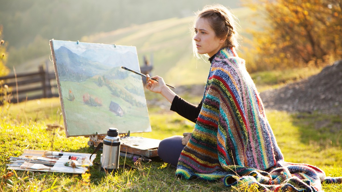 Young artist painting a landscape