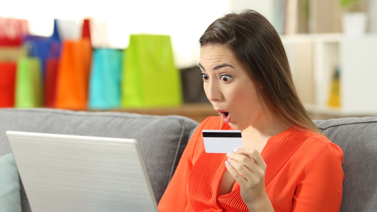 woman shocked with credit card with laptop