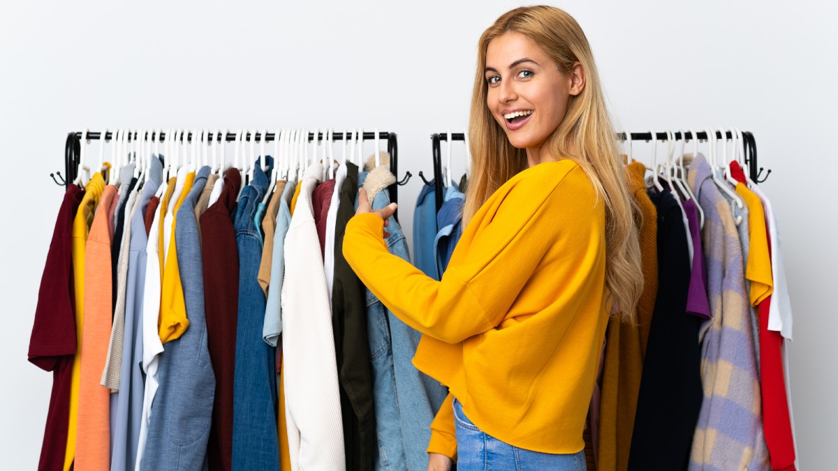 Young Uruguayan blonde woman in a clothing store pointing back