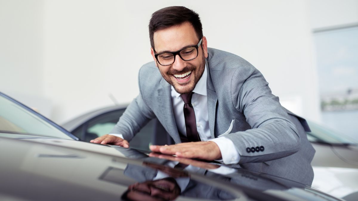 man smiling at his car