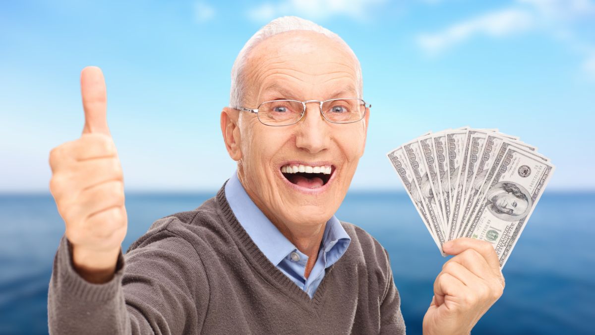 man holding cash in front of water