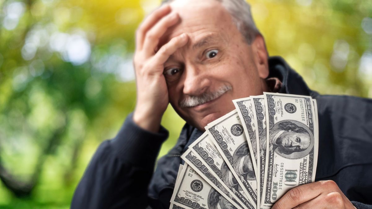 older man with cash in park