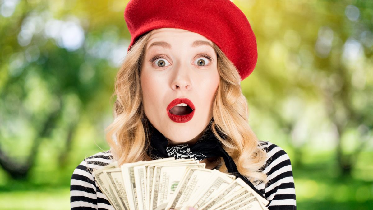 woman holding cash with a hat
