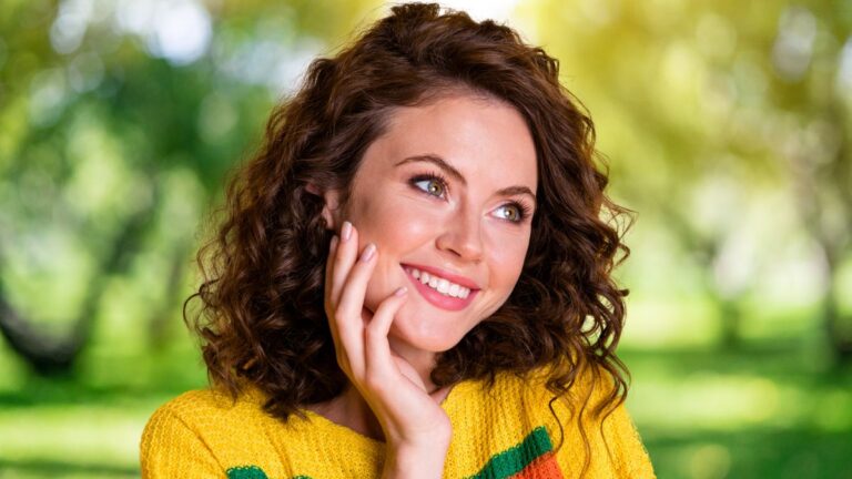 woman smiling standing in park