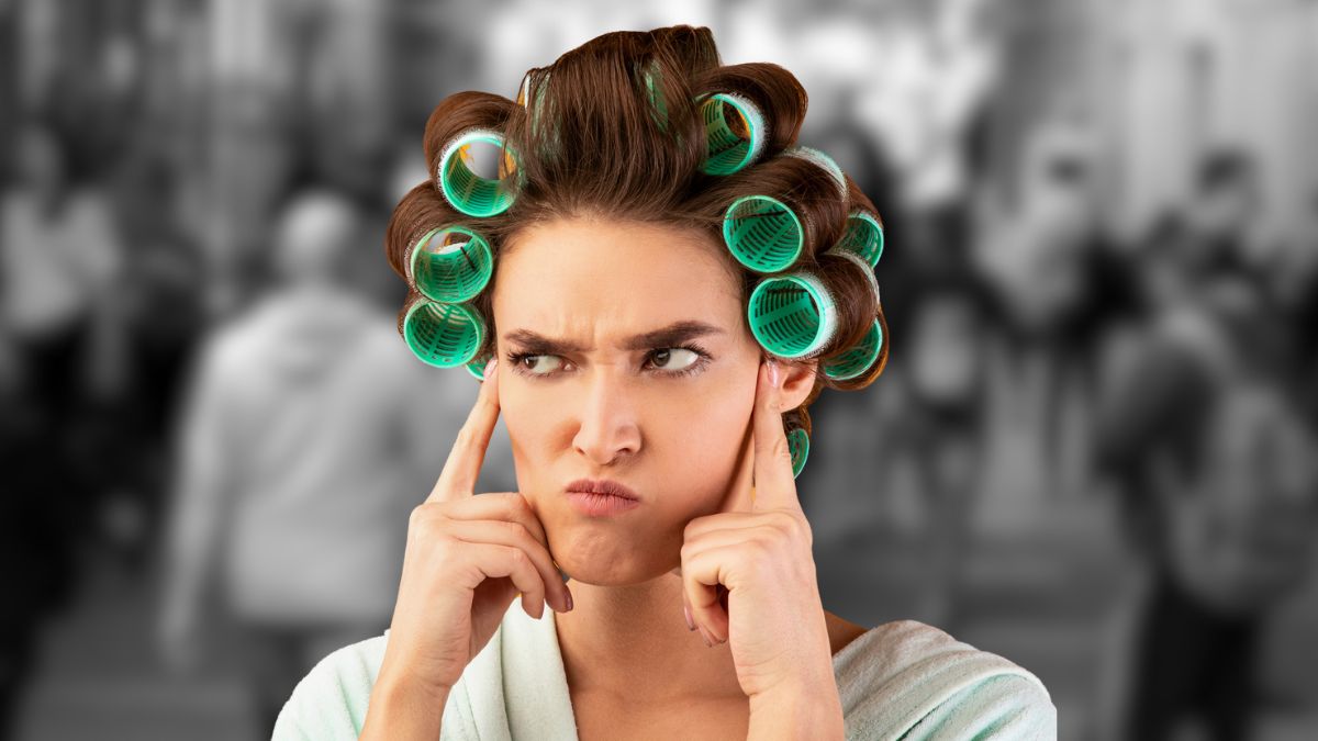 woman with curlers in public covering ears