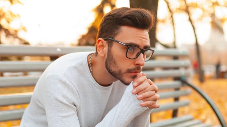 man glasses sitting on a bench