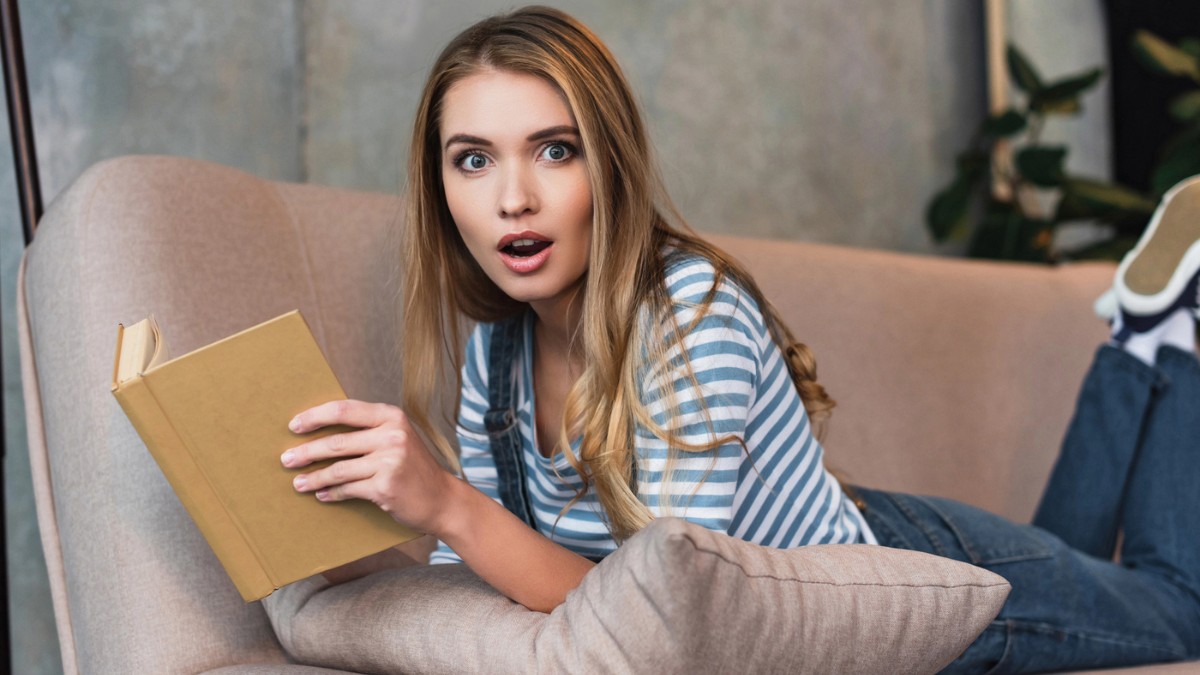 woman with book in shock